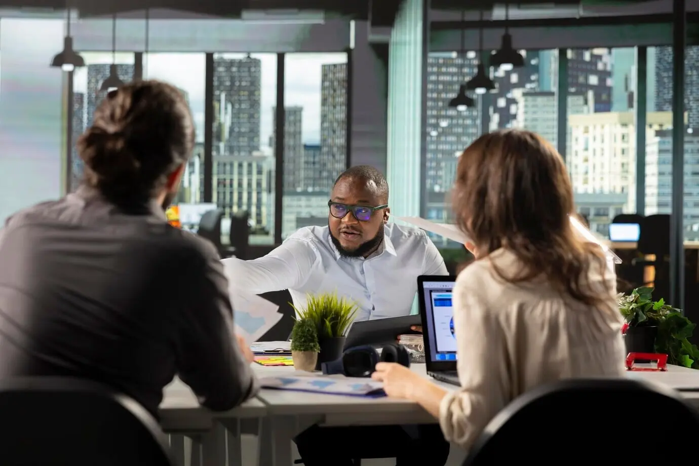 Разнообразная команда сотрудников в многонациональной компании анализирует показатели эффективности и кадровые прогнозы.